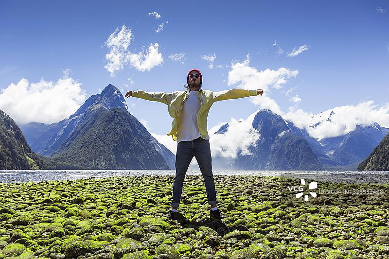 男子在米尔福德峡湾，峡湾国家公园，新西兰南岛图片素材