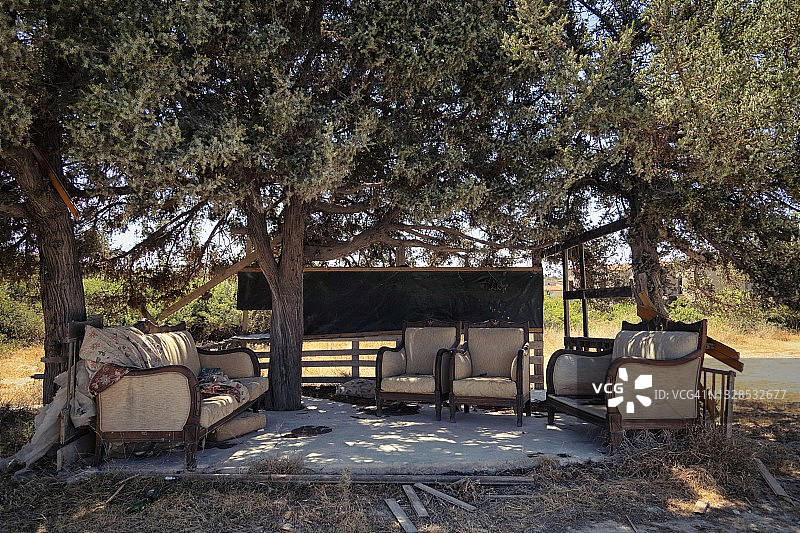 阳光明媚的一天，树下的废弃家具图片素材