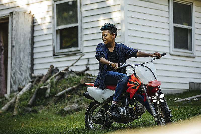 女孩在后院骑泥地自行车图片素材