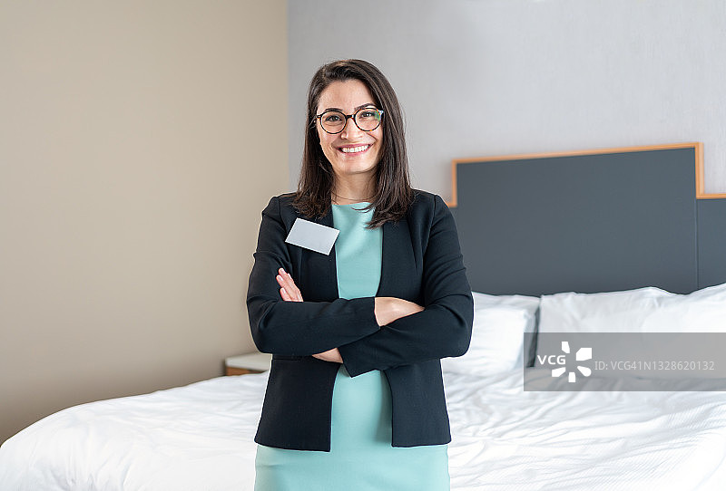 身穿西装站在酒店房间里的美丽酒店经理肖像图片素材
