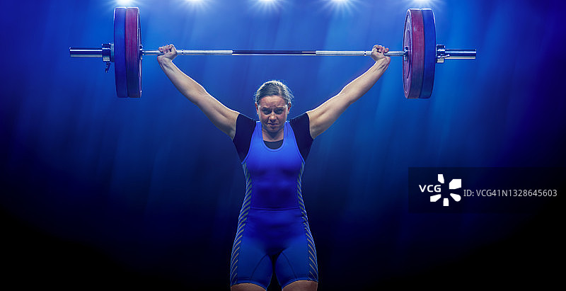 举杠铃的年轻女子举重运动员图片素材