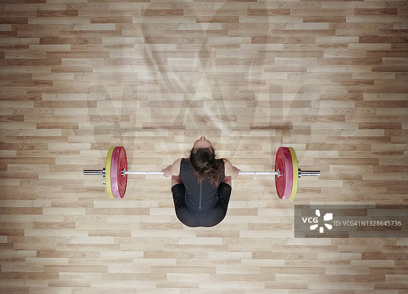 举杠铃的年轻女子举重运动员图片素材