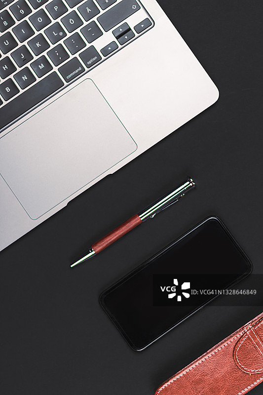平铺办公用品：笔记本电脑、手机与笔图片素材