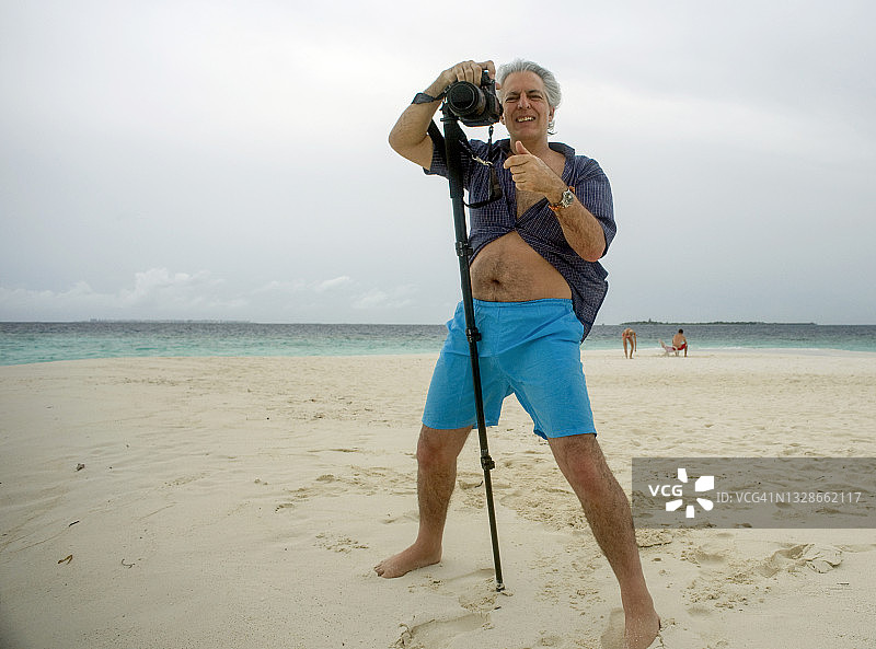 摄影师在马尔代夫海滩上拍摄图片素材
