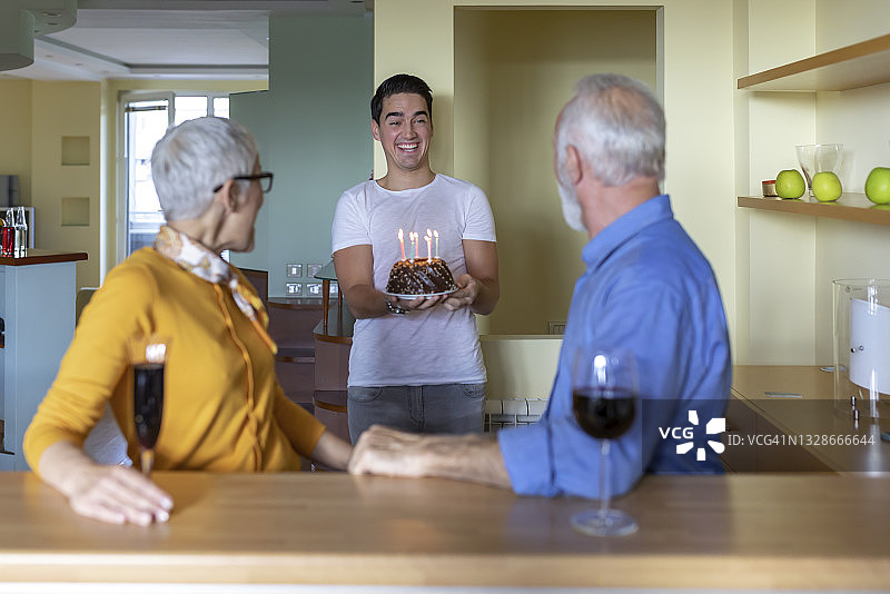 孙子用蛋糕给祖父母一个惊喜图片素材
