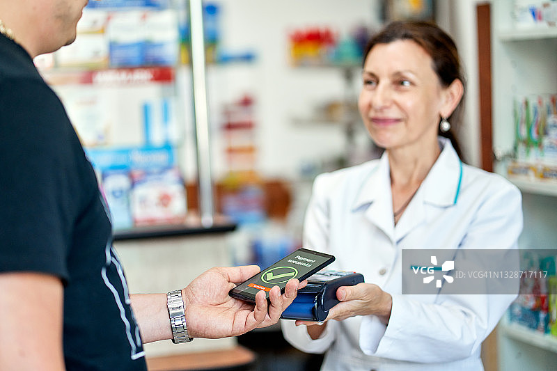 在药房使用智能手机进行非接触式支付图片素材