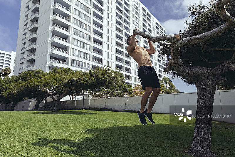 公园中赤膊男运动员引体向上图片素材