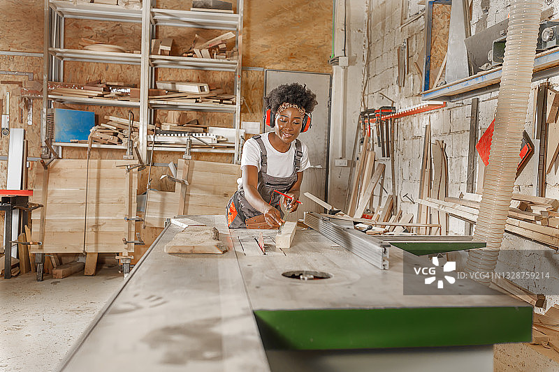 非洲女工正在用卷尺和铅笔进行测量图片素材