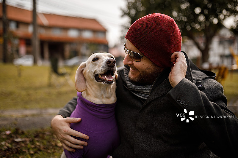 男人拥抱他的狗并大笑图片素材