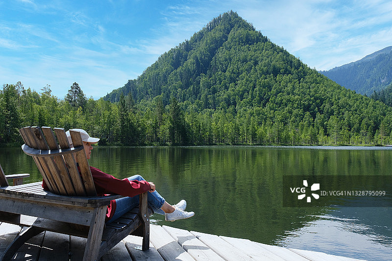 女子在美丽的森林湖边休息图片素材