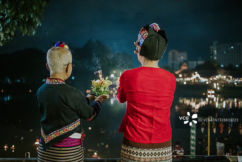 两名积极的泰国妇女穿着泰国当地服装，准备在河上漂浮克拉通以供崇拜图片素材