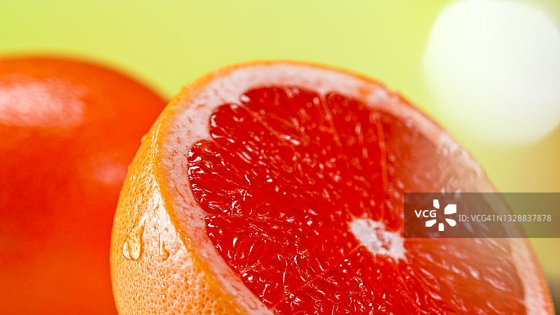 半个红色葡萄柚上的水滴图片素材