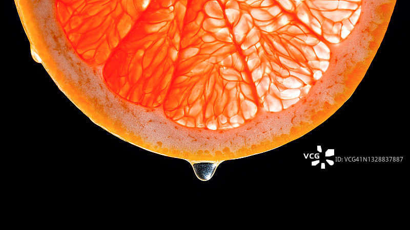 从葡萄柚切片上滴落的水滴图片素材