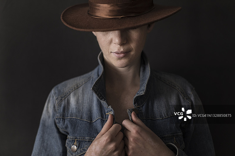 年轻女子身穿牛仔夹克和帽子图片素材