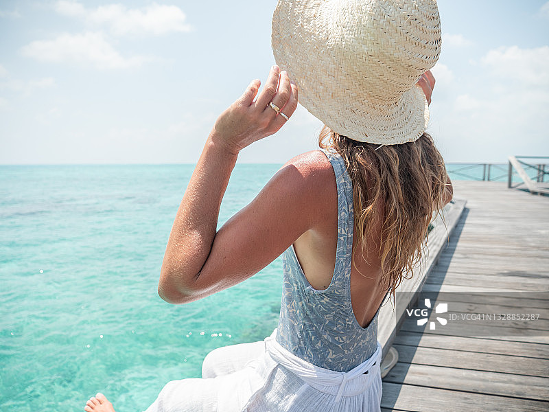 年轻女人在木制码头上沉思礁石图片素材