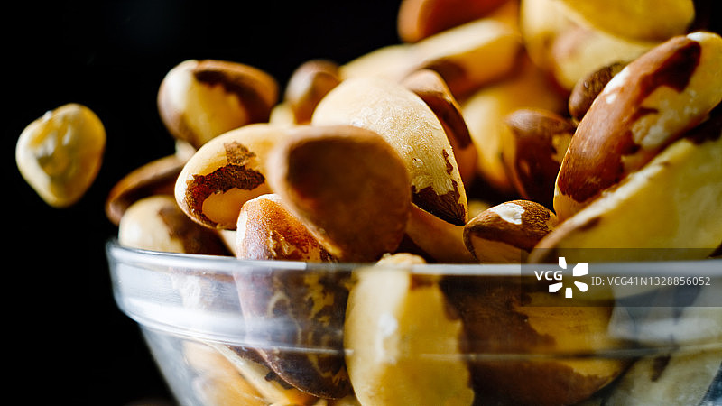 从玻璃碗中溢出的巴西坚果图片素材