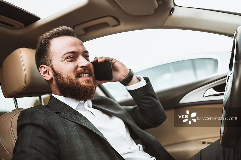 堵车时打电话的微笑英俊商人图片素材