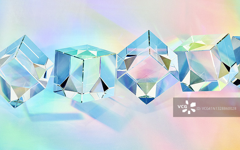 多色背景上的一排透明水晶立方体图片素材