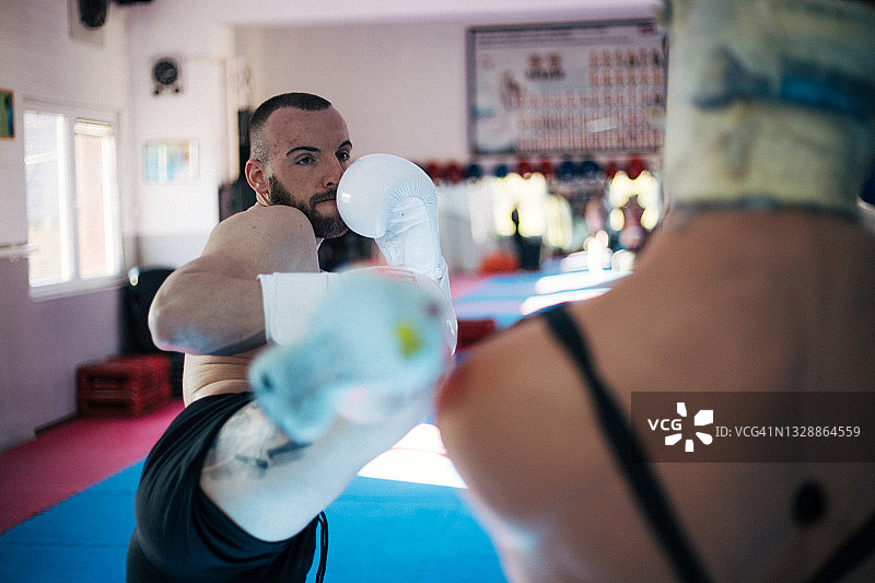 年轻男子专注地进行拳击训练图片素材