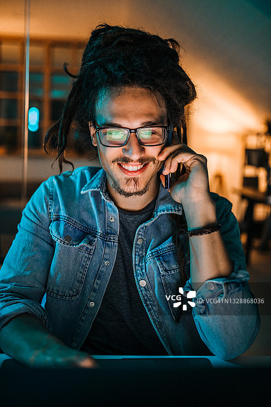 在黑暗的办公室里，年轻有为的英俊商人图片素材