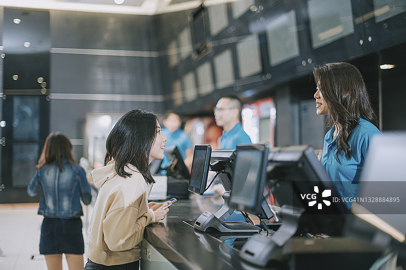 中国观众在电影院售票柜台前购买电影票和爆米花图片素材