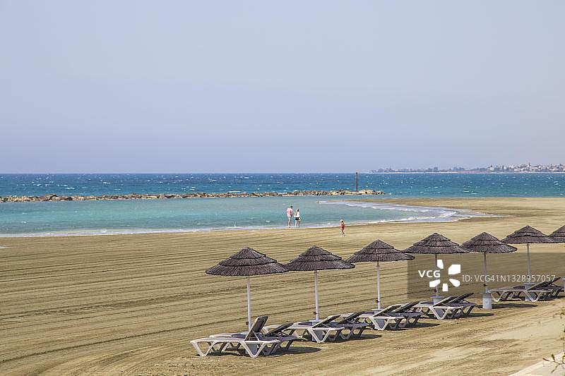 折叠椅、茅草伞和空旷的海滩图片素材