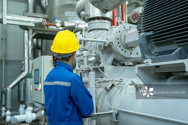 戴头盔的女电气工程师正在检查工业电气操作系统图片素材