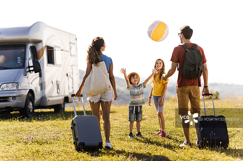 年轻幸福的家庭带着露营拖车去度假图片素材
