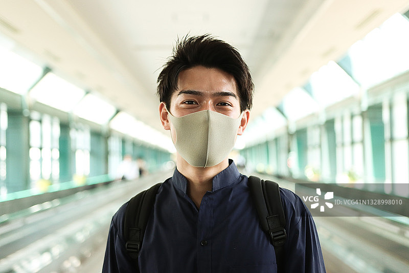 戴防护口罩的微笑亚洲青年男子肖像图片素材