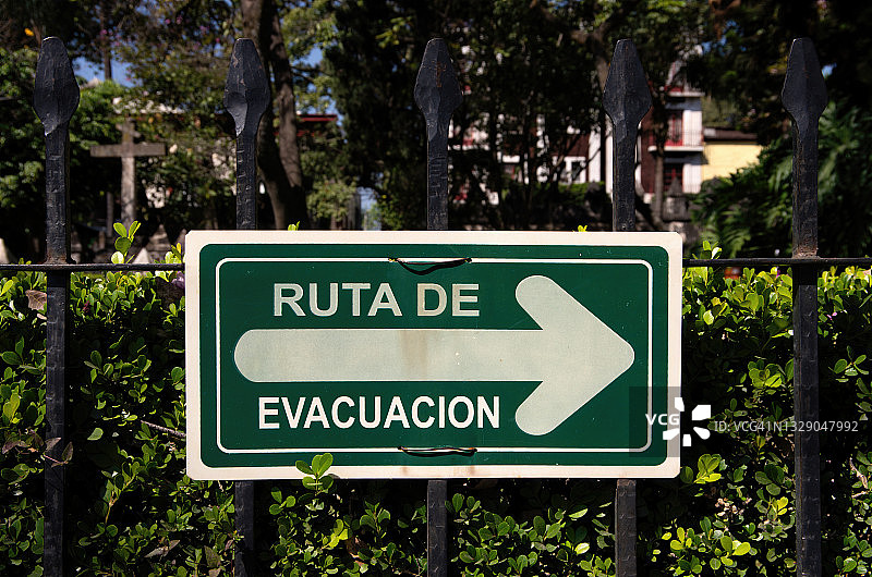 西班牙语“疏散路线”金属栏杆指示牌图片素材