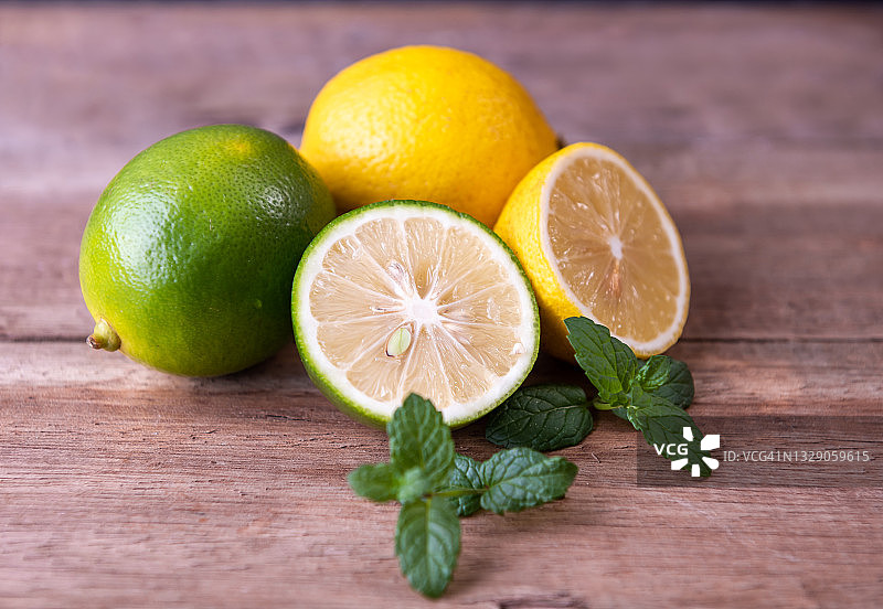 旧木桌上的多汁柑橘 - 青柠、柠檬和薄荷图片素材