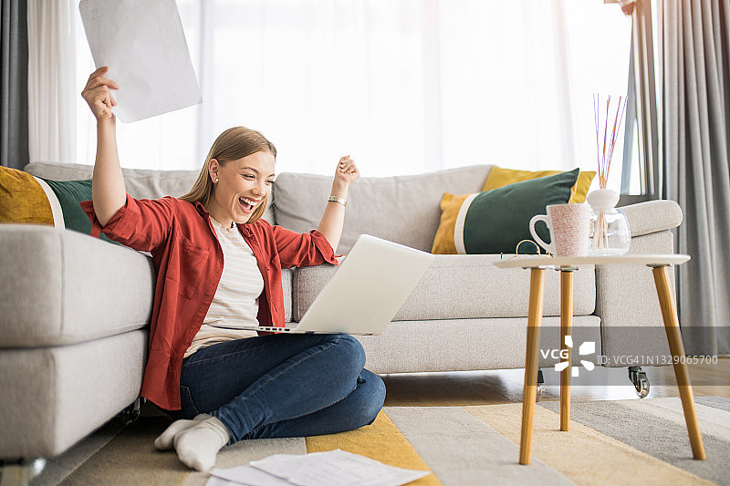 在家工作并庆祝的快乐年轻女人图片素材