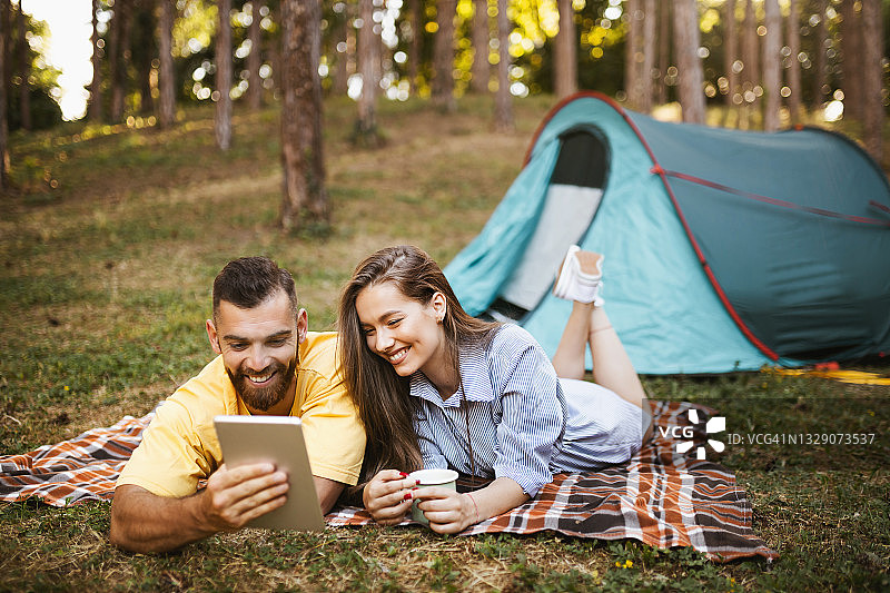 情侣在森林露营时进行视频通话图片素材