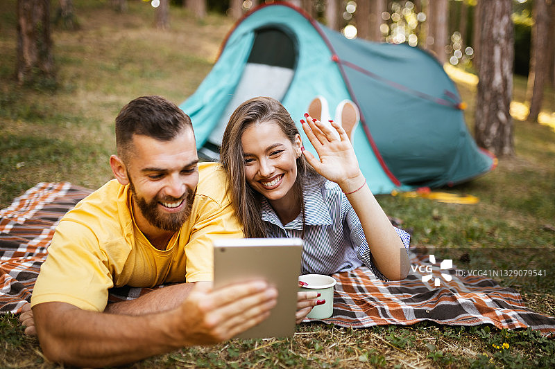 情侣在森林露营时进行视频通话图片素材