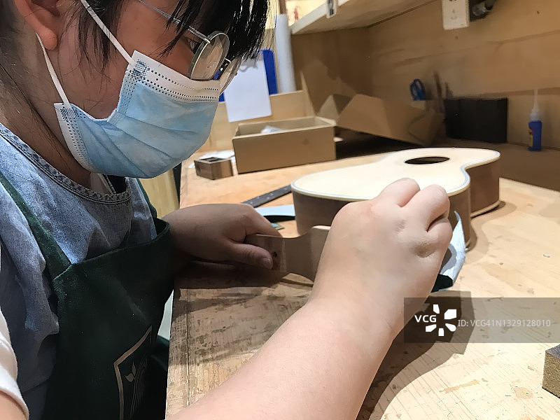 女孩正在制作木吉他图片素材
