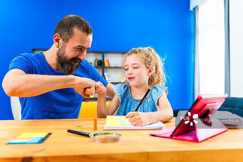 父亲和女儿在家学习，享受亲子时光图片素材