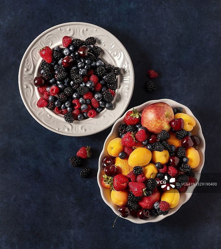 深蓝色背景上两碗新鲜水果图片素材