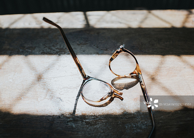 阳光明媚的木桌上断裂的眼镜图片素材