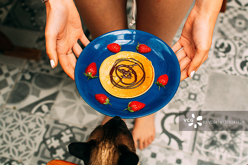 盘子里的即食煎饼，少女的身体和暹罗猫图片素材