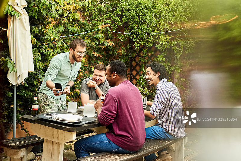 朋友们在后院聚会时看手机图片素材