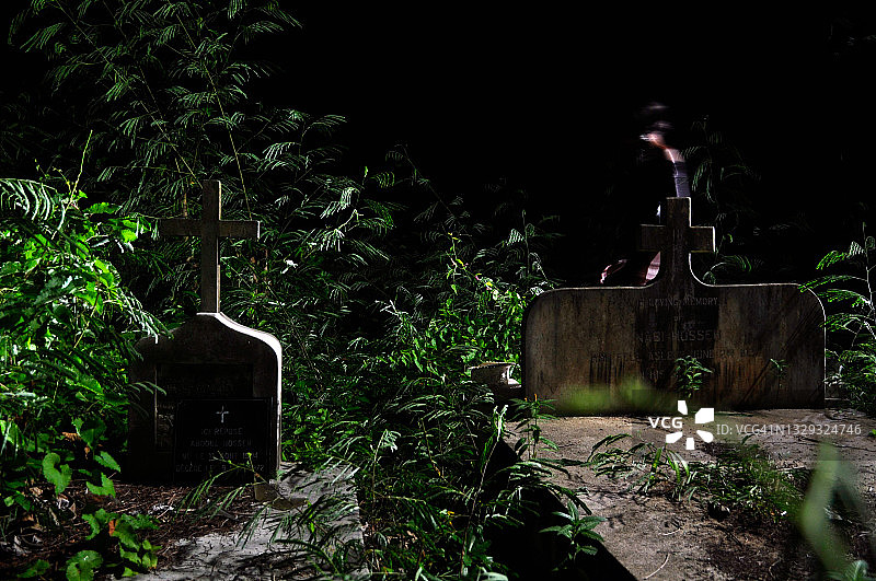 夜晚墓地中植被对比光下的模糊行走图片素材