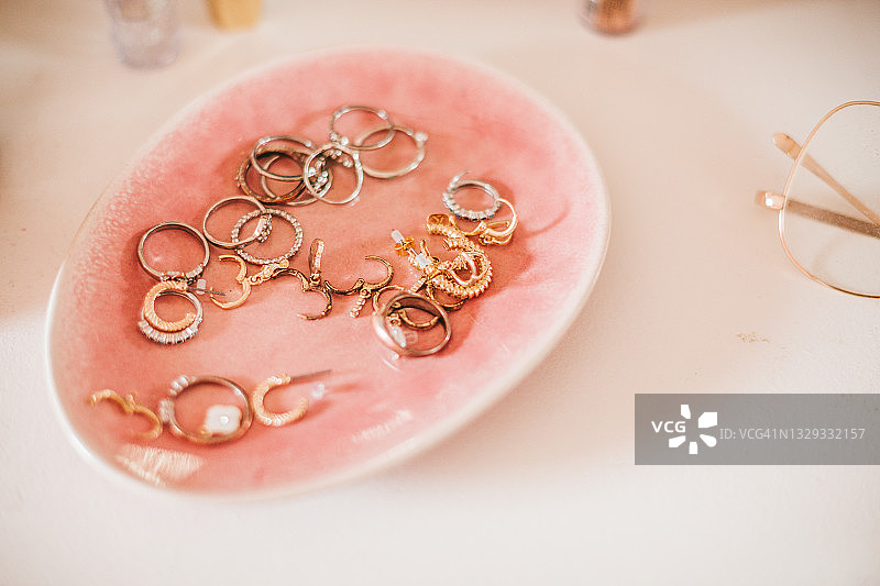 粉色陶瓷托盘上的耳环：时尚博主概念图片素材