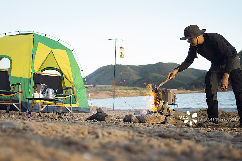 男人在篝火旁取暖图片素材