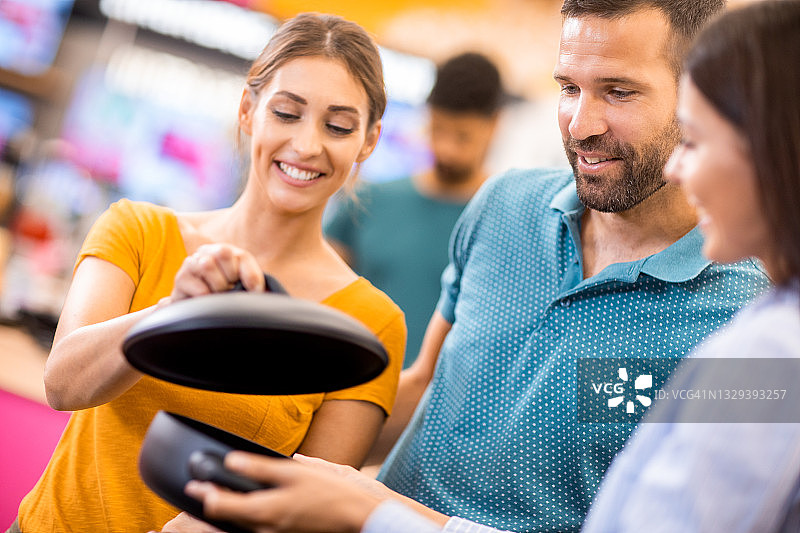 女店员向年轻夫妇展示菜品图片素材