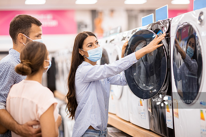 戴口罩的情侣选择烘干机图片素材
