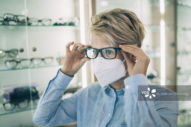 戴着防护面罩，戴新眼镜的年轻女子特写图片素材