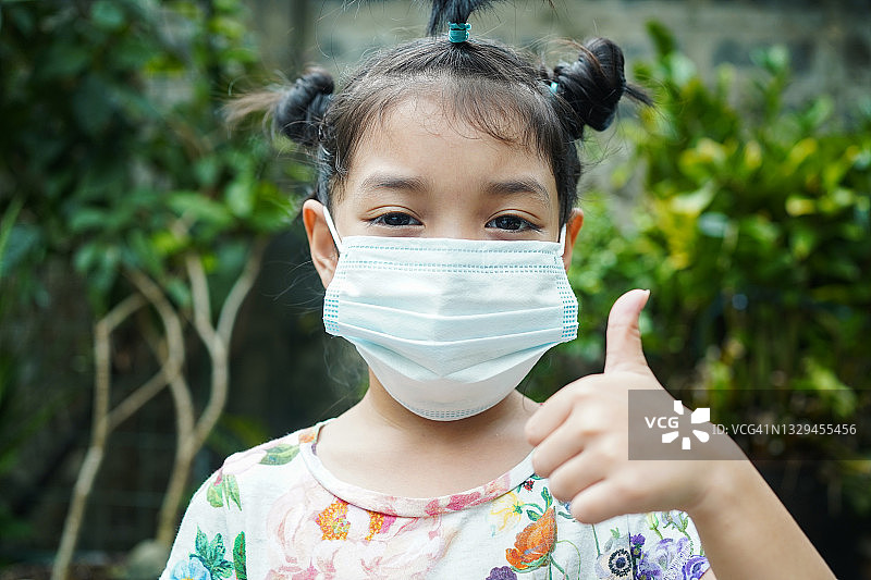 亚洲儿童戴着医用口罩或外科口罩，以保护自己免受病毒、疾病、新冠肺炎和冠状病毒感染图片素材