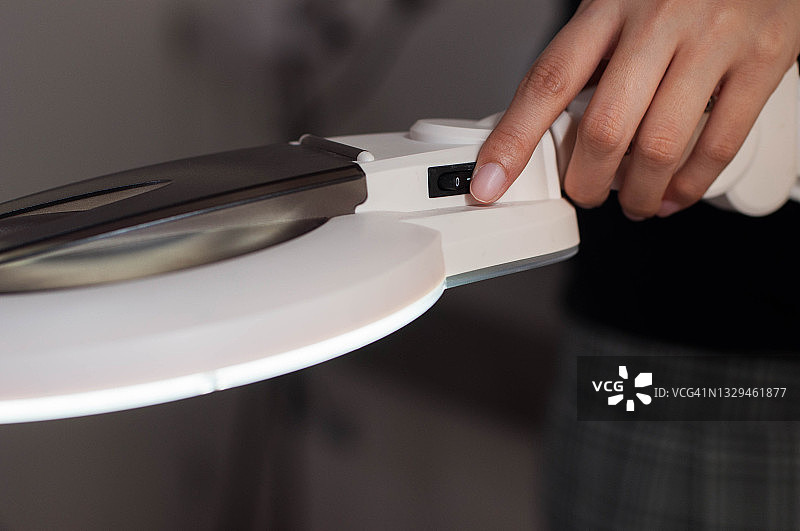 一名东南亚年轻女子正在打开室内灯的开关图片素材