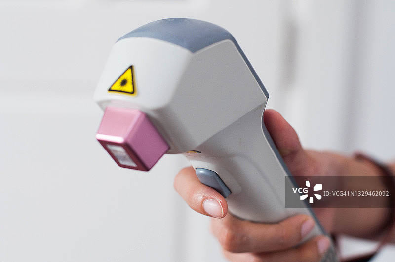 一位年轻的东南亚女医生正在使用激光进行医疗操作图片素材