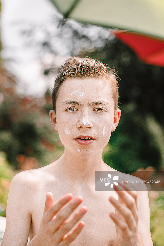 脸上涂着防晒霜的西班牙裔男孩图片素材